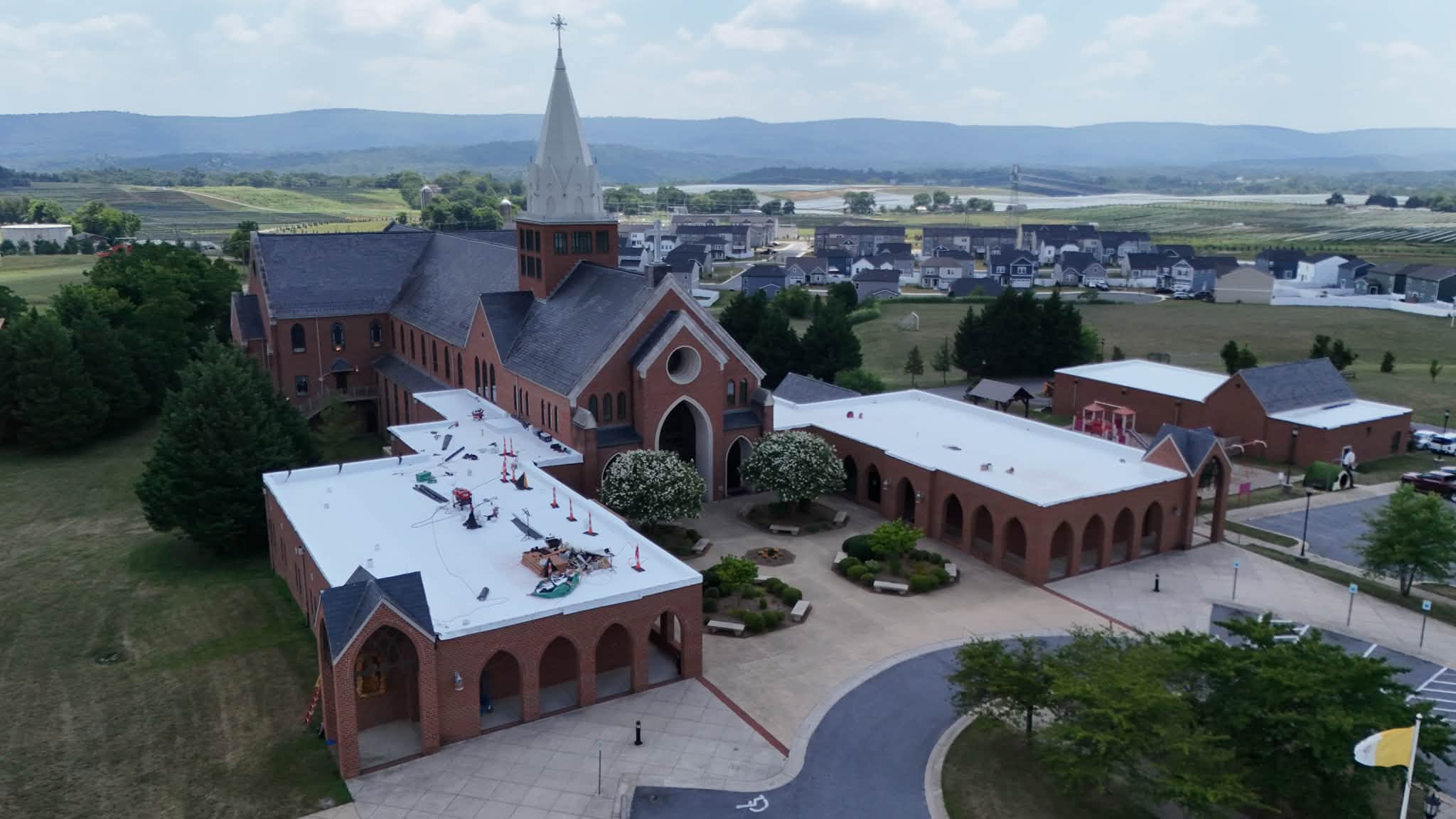 Black Stone Roofing membrane roof work staged on the flat roofs of a brick church campus