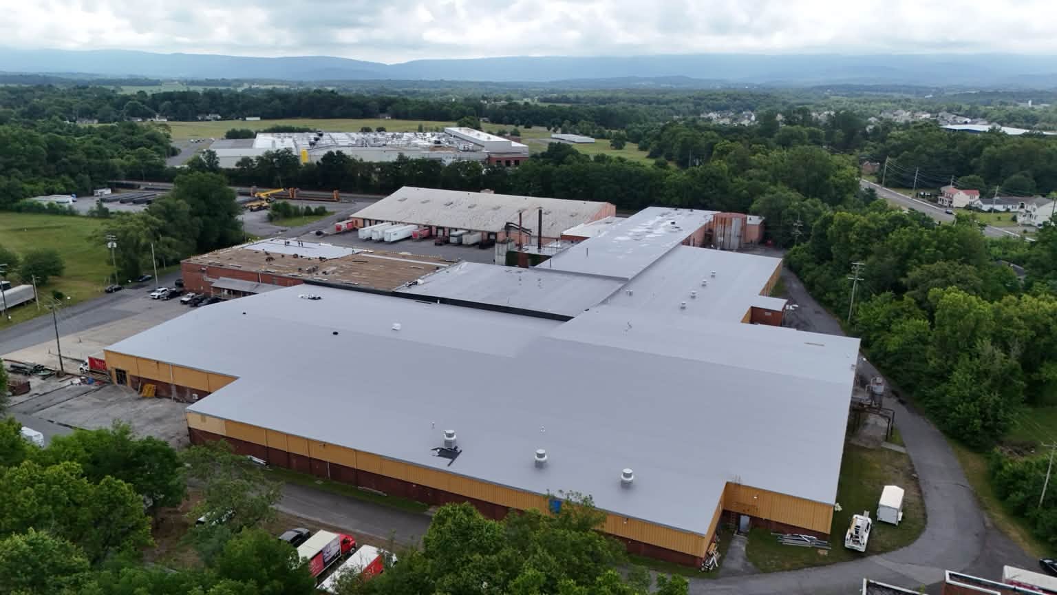 Completed gray single ply membrane roof by Black Stone Roofing on a large commercial warehouse