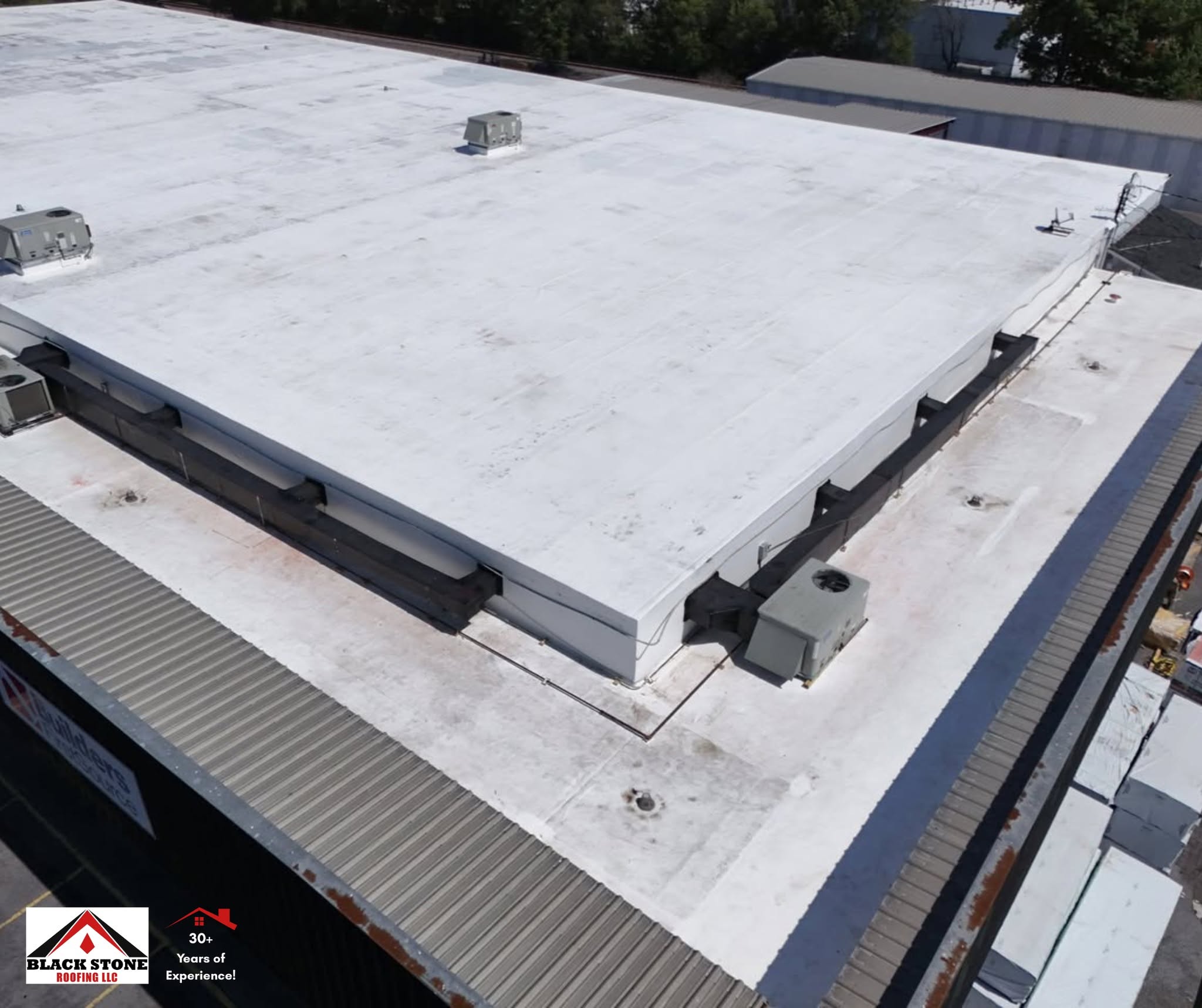 Close aerial detail of a white membrane commercial roof system installed by Black Stone Roofing