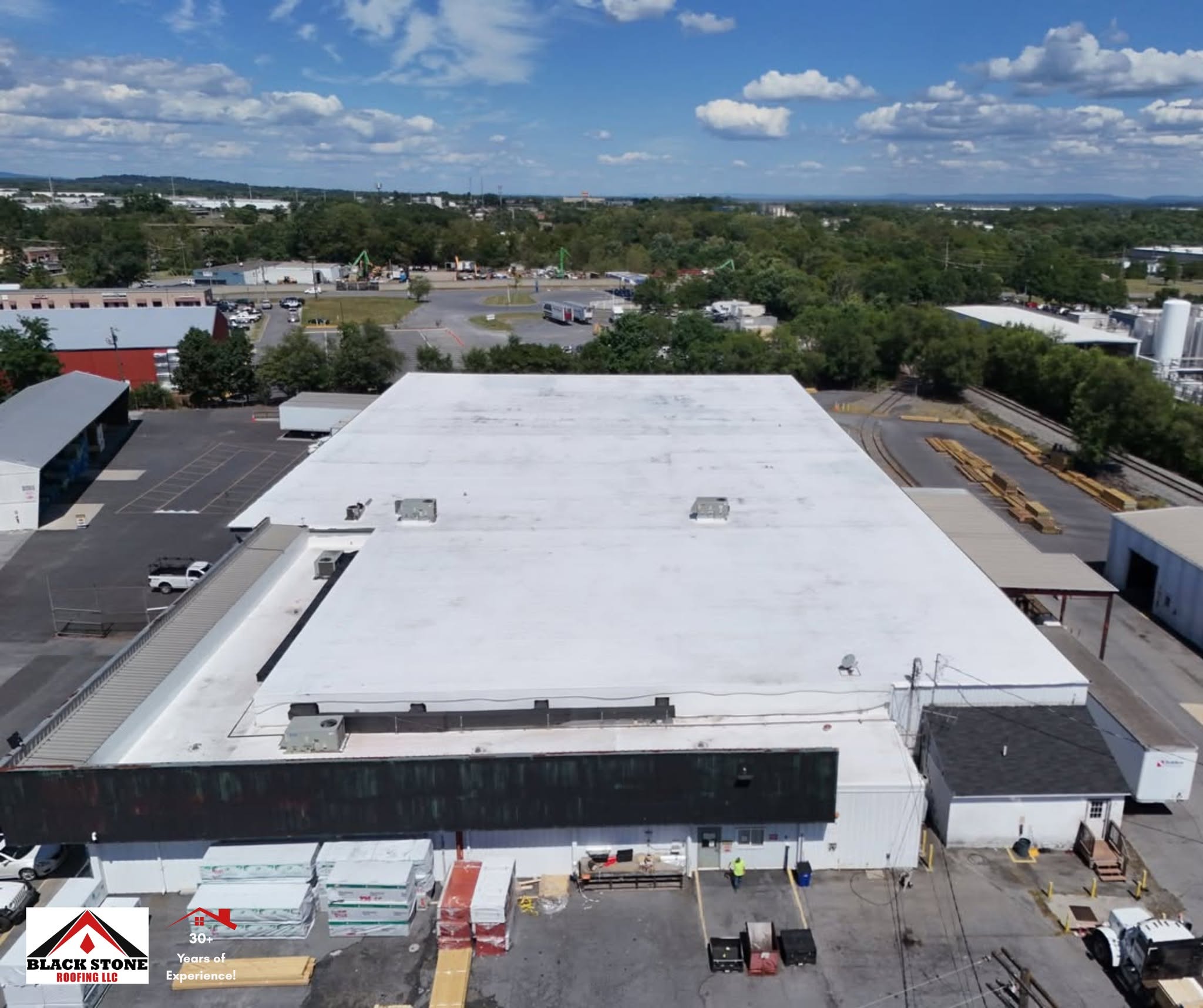 Drone photo of a commercial building with a white membrane roof completed by Black Stone Roofing